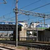 Accediamo cos� ai binari concludendo il nostro viaggio, mentre in alto, su un ponte, due treni quasi si sfiorano tra un groviglio di tralicci